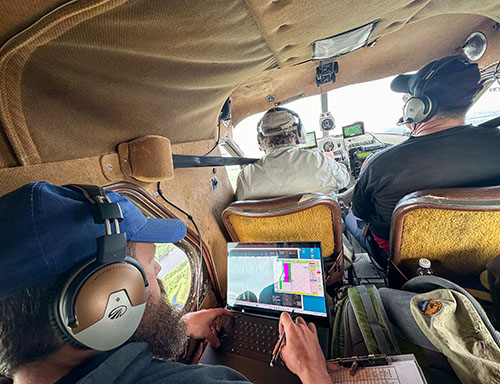 Nate Pamperin back left uses the computer to set up a pass to photograph wood bison while Bruce Dale pilots the Beaver and Al Barette looks on