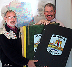 McKie Campbell right and Chuck Meacham with a collection of newspaper articles detailing fish and game issues dating back to statehood