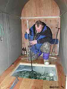 Spearfishing inside an icehouse on Lake George in Interior Alaska Photo by Fronty Parker