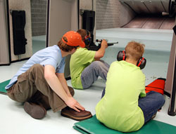 Youth campers receive instruction from hunter education instructor Bryce Burns far left during a 22caliber rifle shooting session at the Alaska Department of Fish amp Game Hunter Education Indoor Shooting Range