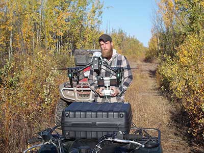 Drone operator Rion Sabin watches closely as his drone lifts off Sabin gathered aerial images to help with project planning and to identify the species of trees in specific stands