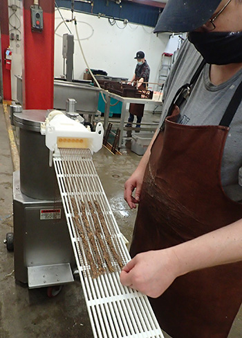 Scott shows the extruder using finished treats to show how the damp extruded product comes outIt is dried so it contains lass than one percent moisture