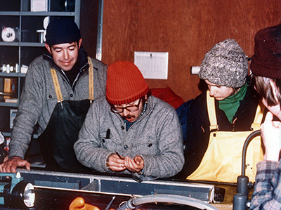 Fin clipping and tagging coho salmon in the Fish Creek float house 1977 Sam Bertoni middle red hat