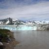 The Copper River sonar site is downstream of Miles Lake Glacier and Million Dollar Bridge, and upstream of Childs Glacier. In this photograph taken from the bridge, Childs Glacier is pictured in the background.
The sonar site’s left-bank shelter and the top of a submerged sonar transducer is 
pictured in the lower left-hand corner.